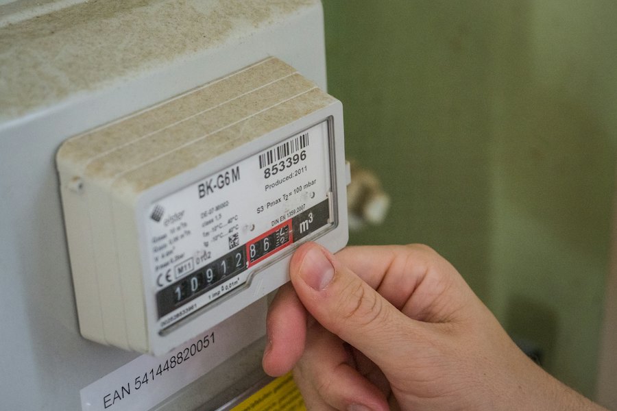 Main près d'un compteur d'énergie mesurant la consommation électrique